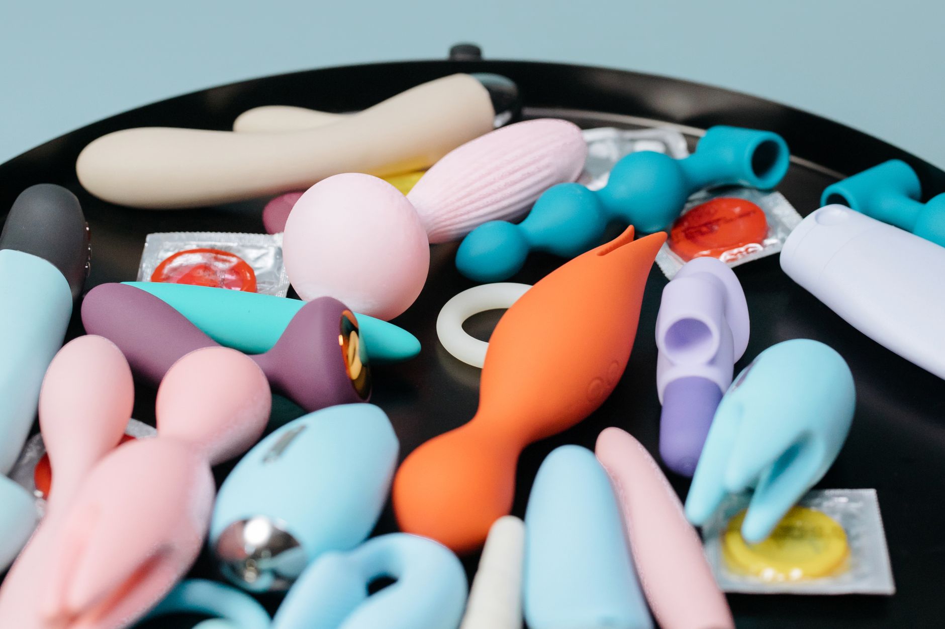 A vibrant collection of sex toys and lubricants on a dark surface, ready for intimate use.