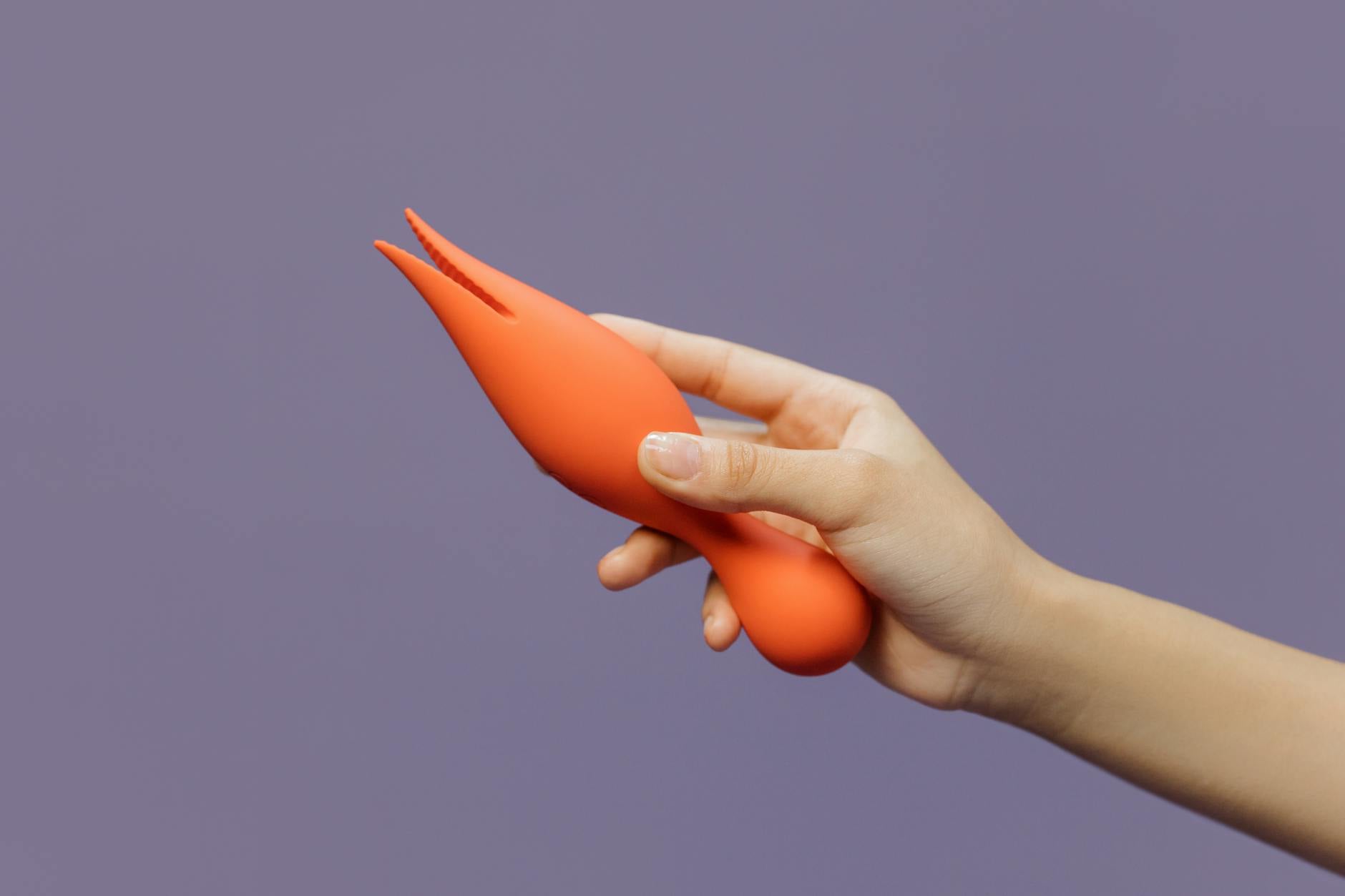 Hand holding a lemon vibrator against a minimalist backdrop, symbolizing reconnection to pleasure