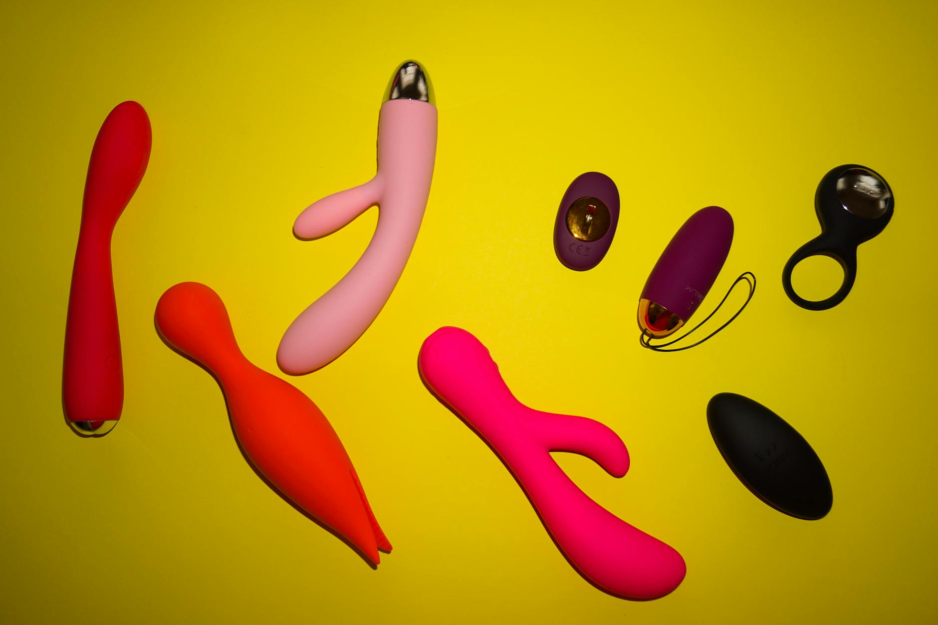 A woman holding colorful vibrators, representing tools for reconnecting with pleasure