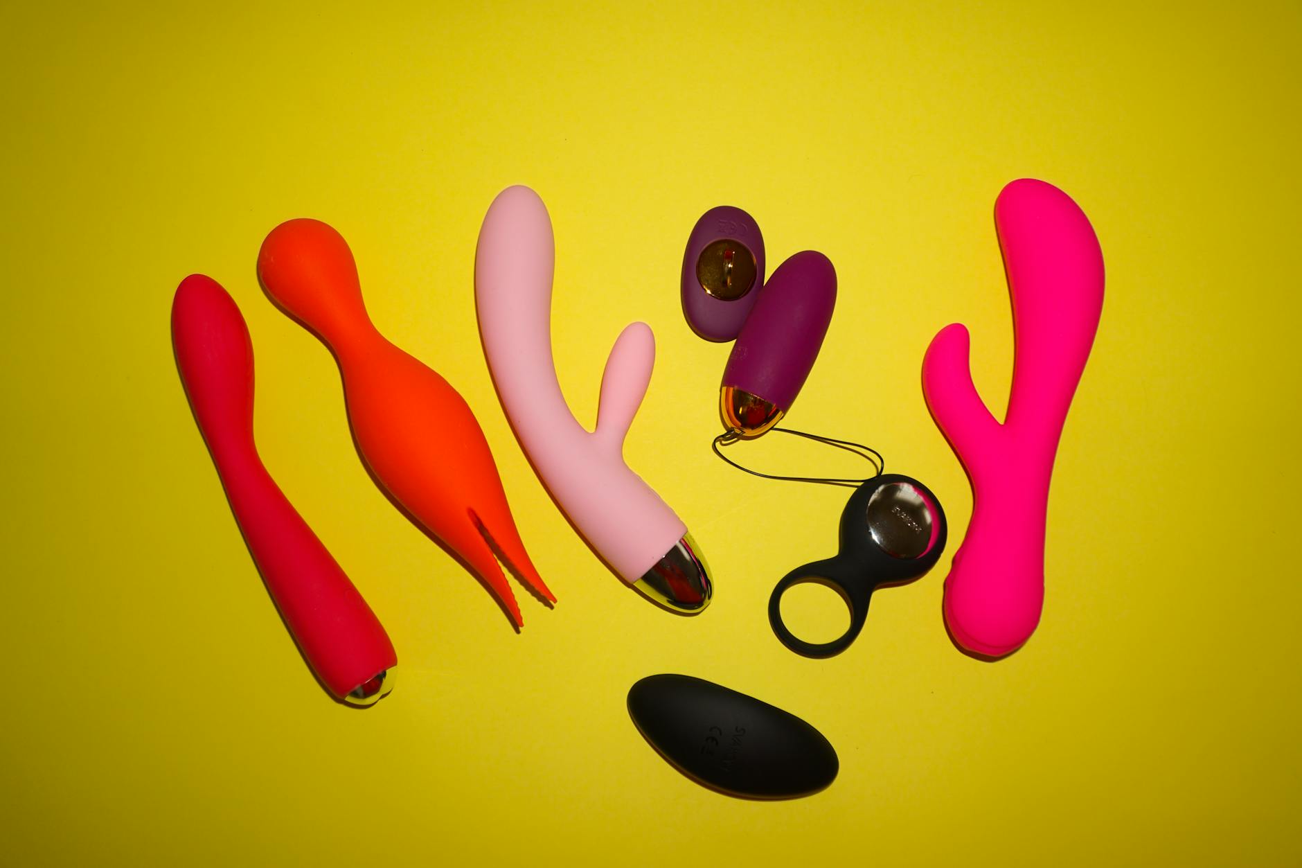 Colorful lemon vibrators and adult toys arranged on a bright yellow background
